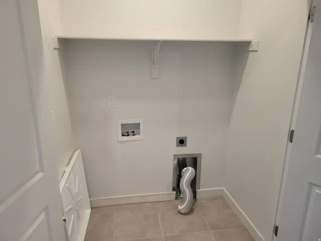 Laundry area with washer hookup, light tile patterned floors, and hookup for an electric dryer