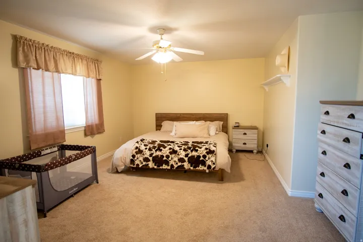 Bedroom featuring light colored carpet and ceiling fan
