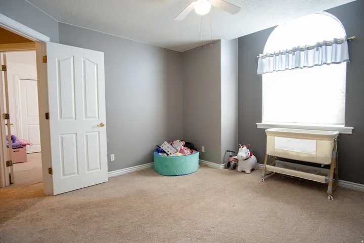 Recreation room featuring a textured ceiling, carpet flooring, and a ceiling fan