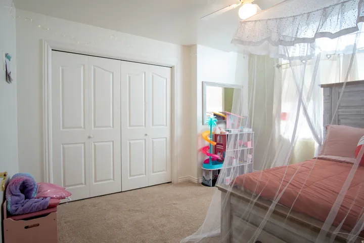 Bedroom with light colored carpet, a closet, and ceiling fan