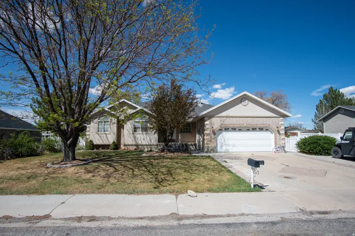 Ranch-style home featuring driveway, an attached garage, and brick siding