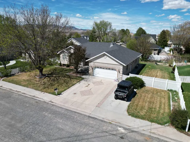 View of front of house with a garage, brick siding, concrete driveway, and roof with shingles