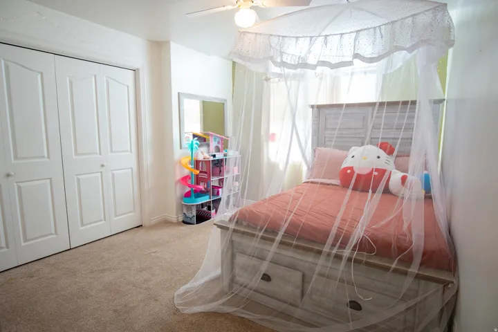 Bedroom with light carpet, a closet, and a ceiling fan