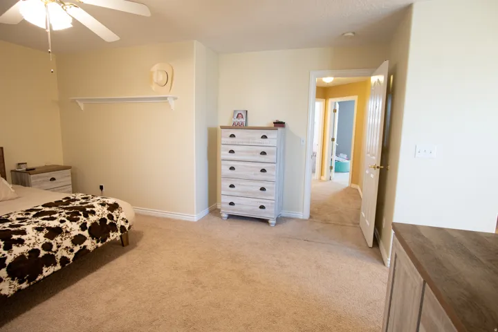 Bedroom featuring light colored carpet and a ceiling fan