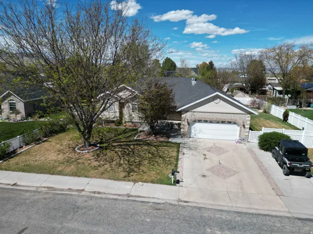 Ranch-style house featuring driveway, a garage, a residential view, and brick siding