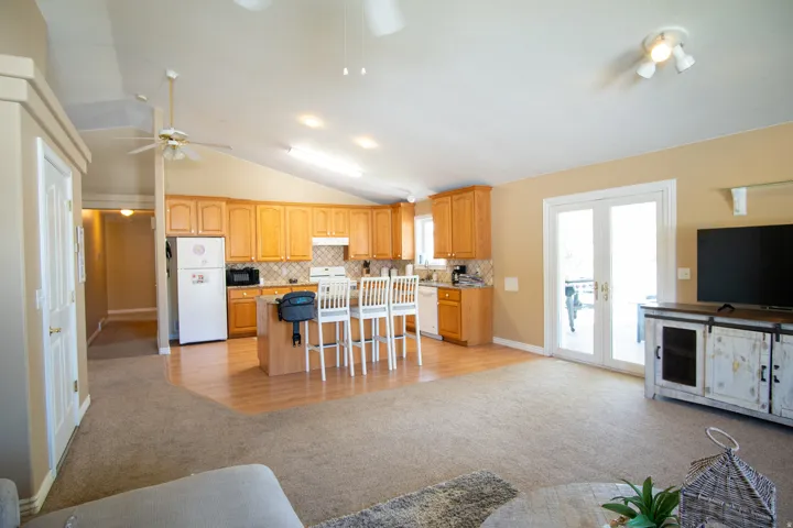 Kitchen featuring a center island, a kitchen breakfast bar, backsplash, light carpet, and open floor plan