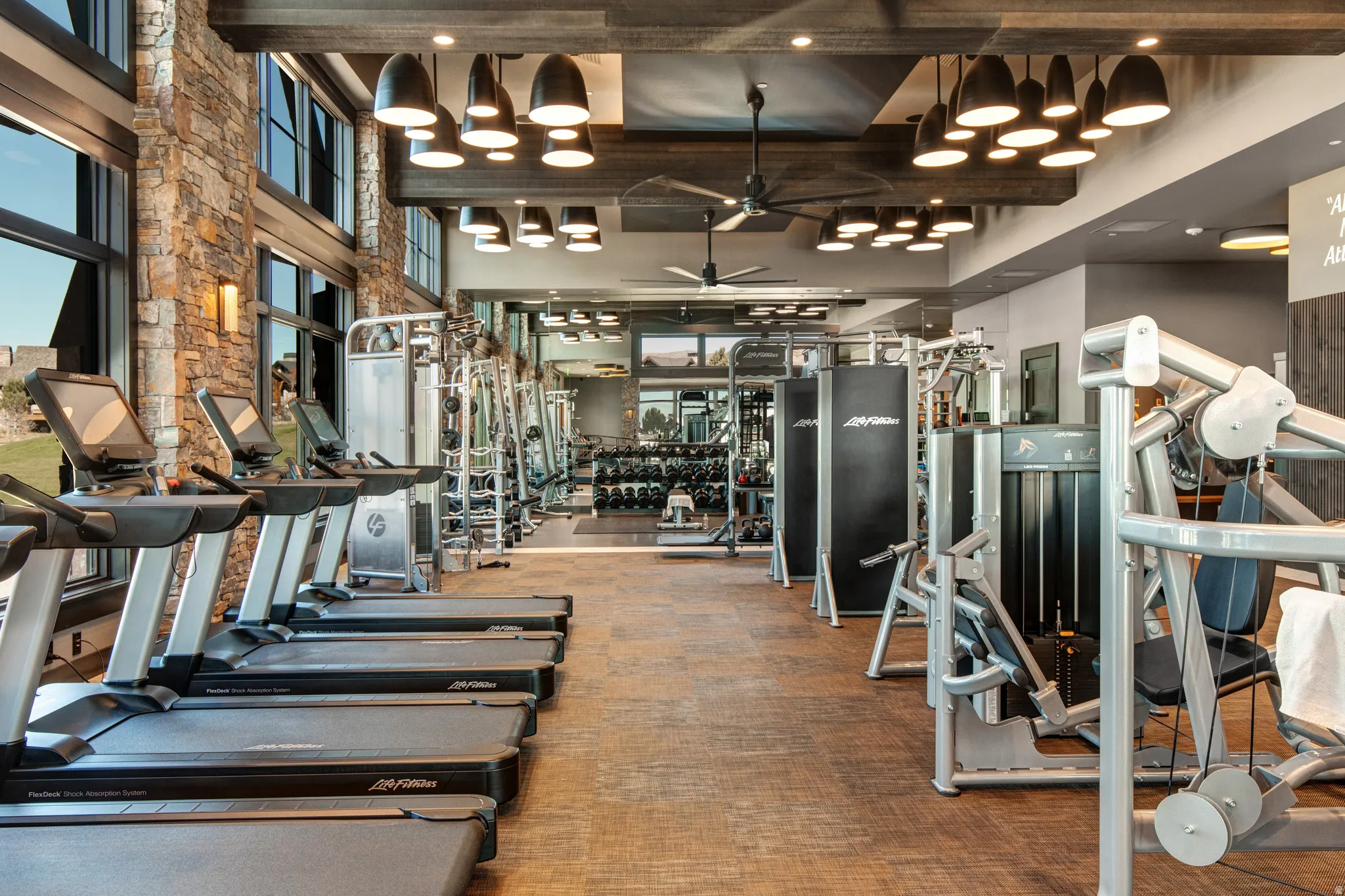 Gym with a ceiling fan and a high ceiling