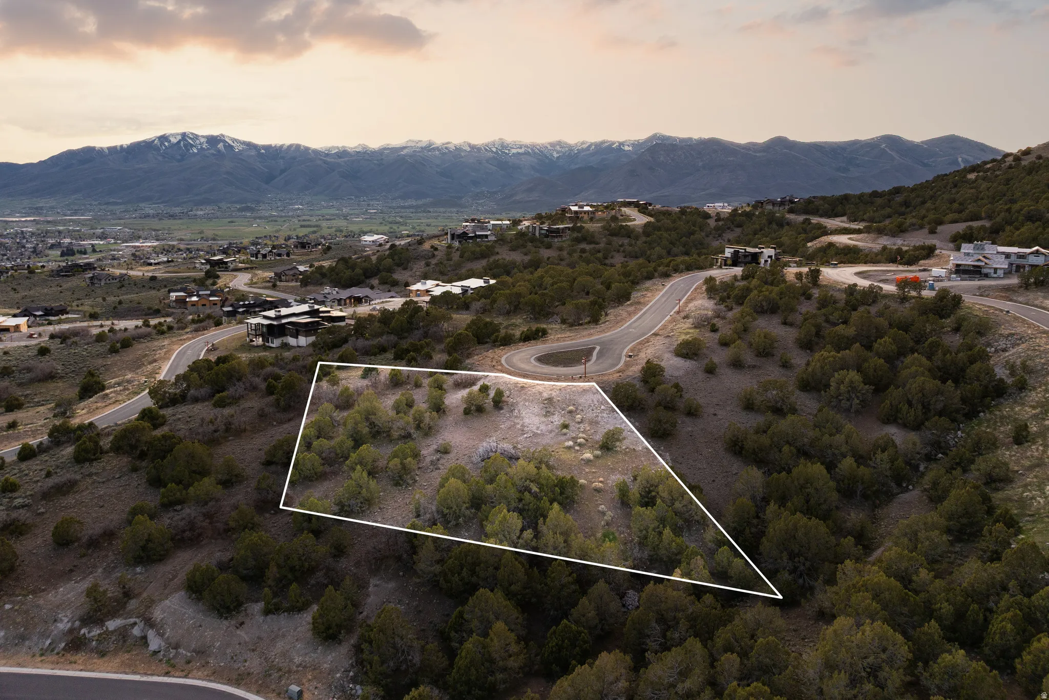 Aerial view of property and surrounding area featuring mountains and property boundaries highlighted