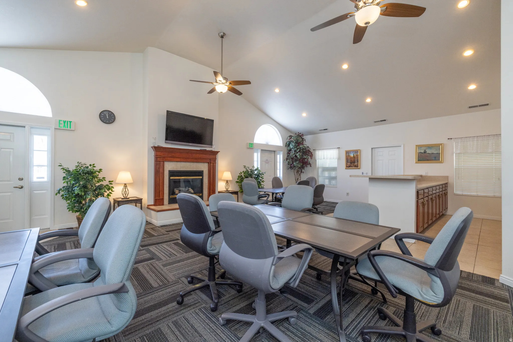 Clubhouse community space featuring recessed lighting, ceiling fan, lofted ceiling, and a glass covered fireplace