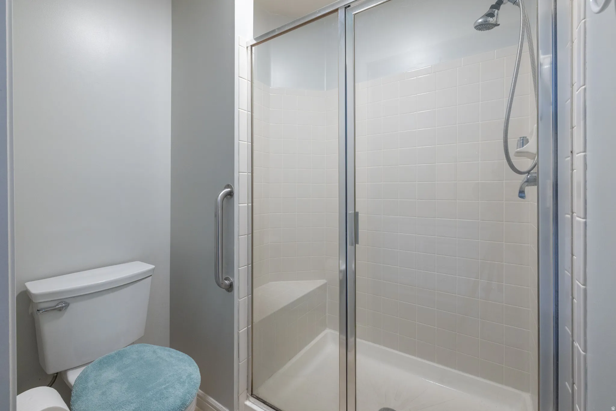 Bathroom featuring a shower stall and toilet