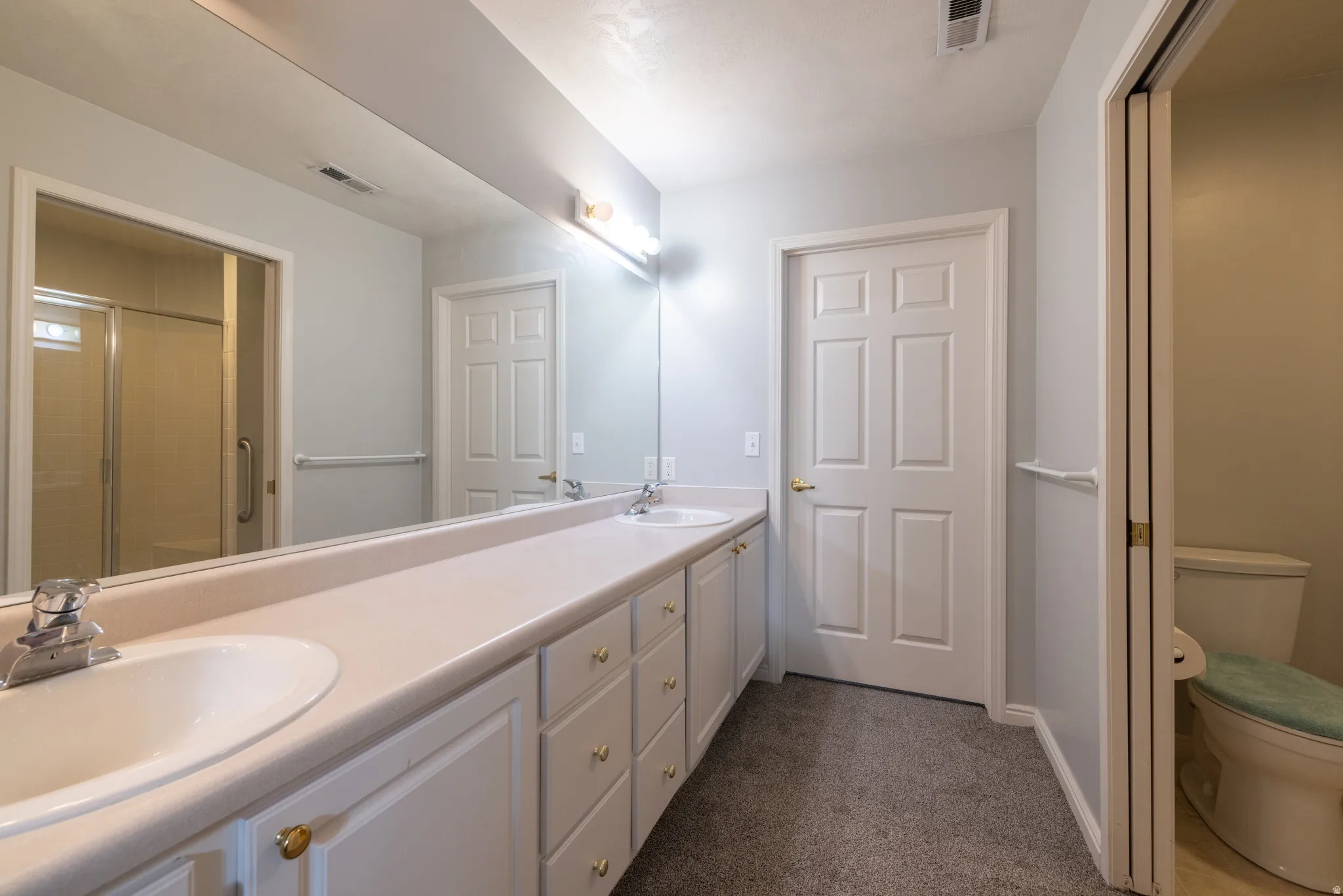 Primary Full bathroom featuring double vanity, bathroom, and walk in closet.