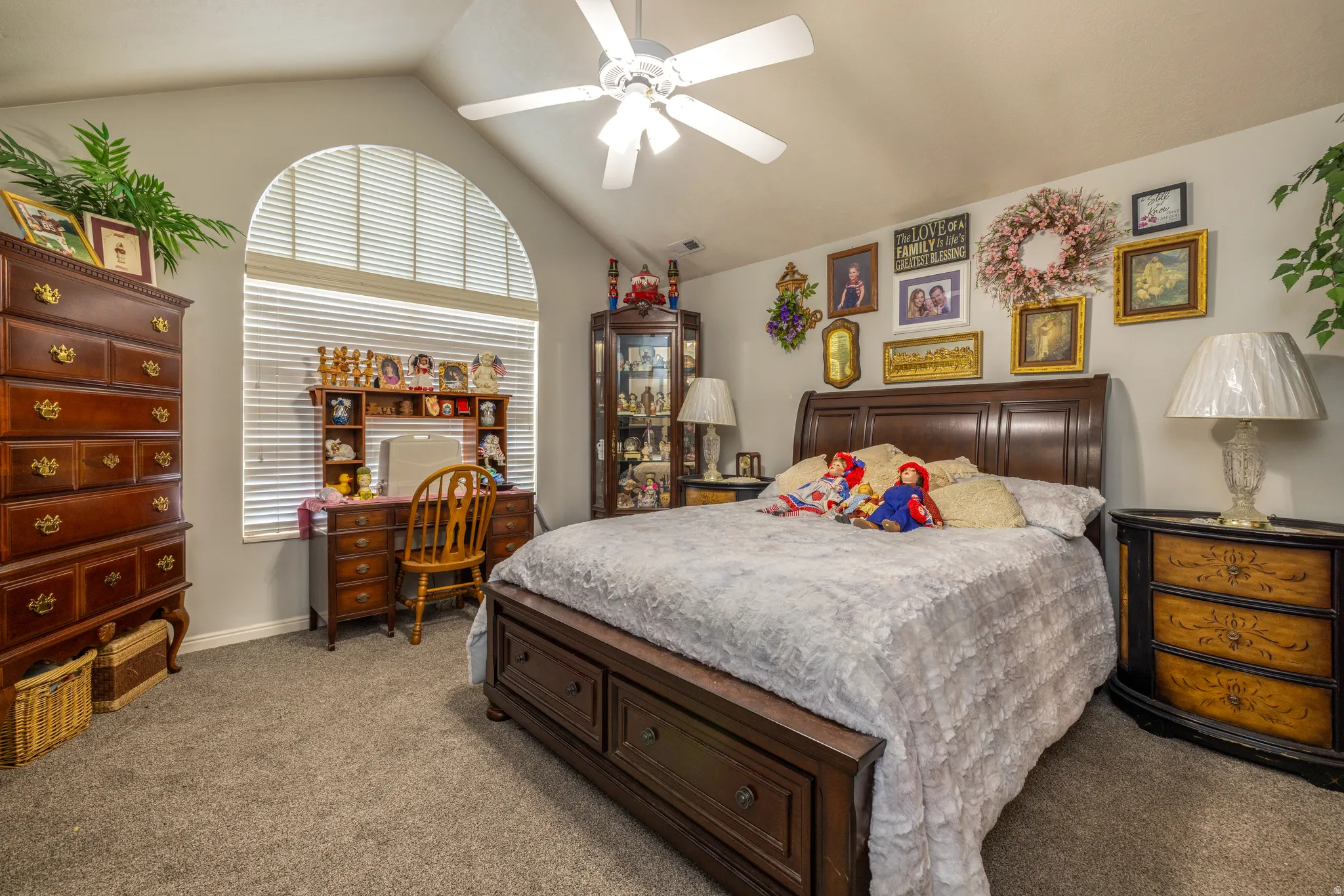 Primary Bedroom featuring a ceiling fan and light colored carpet. Ensuite bath and walk in closet