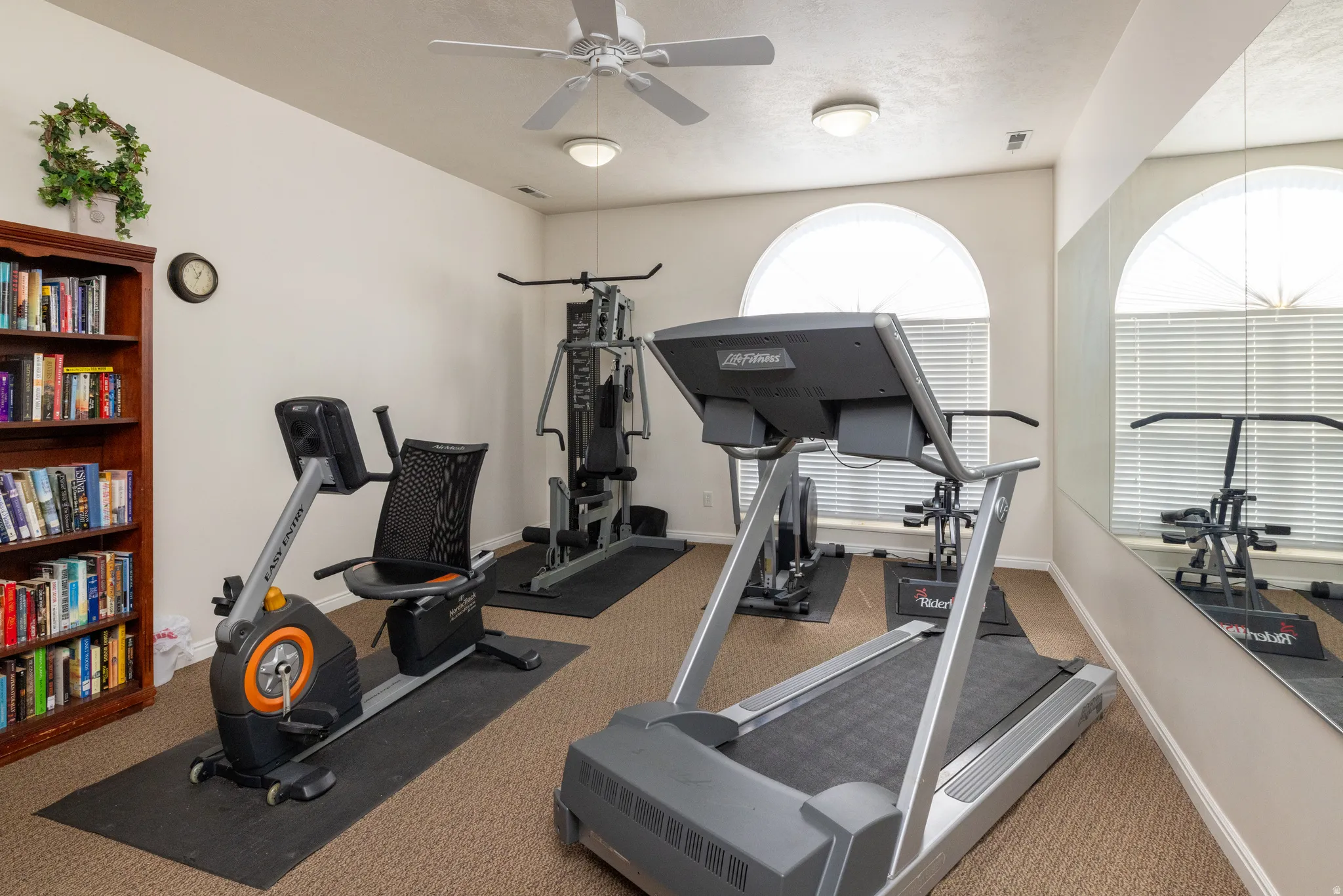 Workout area with ceiling fan and carpet flooring