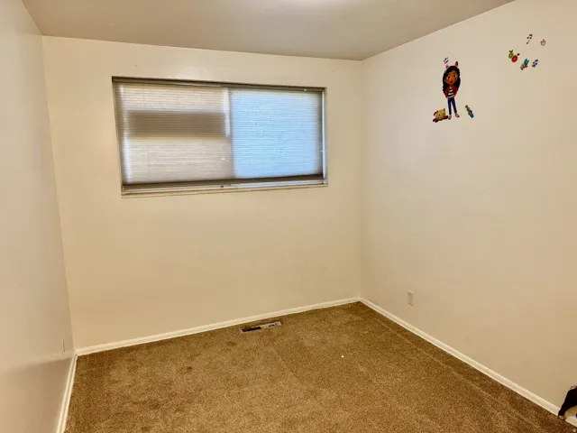Empty room featuring carpet floors and baseboards