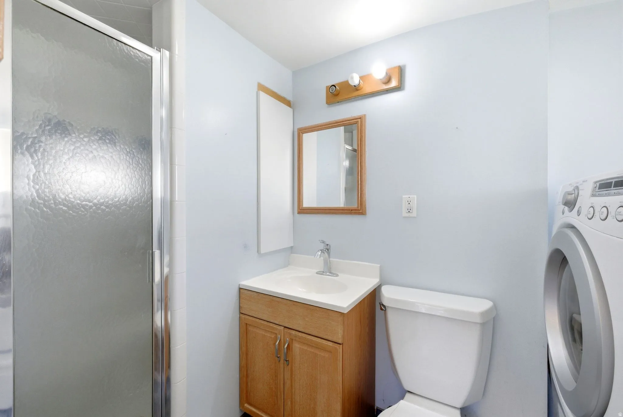 Full bath featuring vanity, washer / dryer, and a stall shower