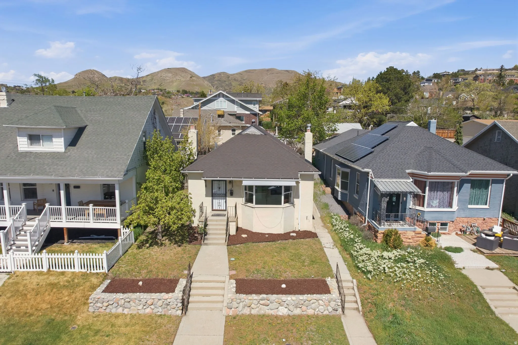 View of front of home featuring a shingled roof, a residential view, and a mountain view
