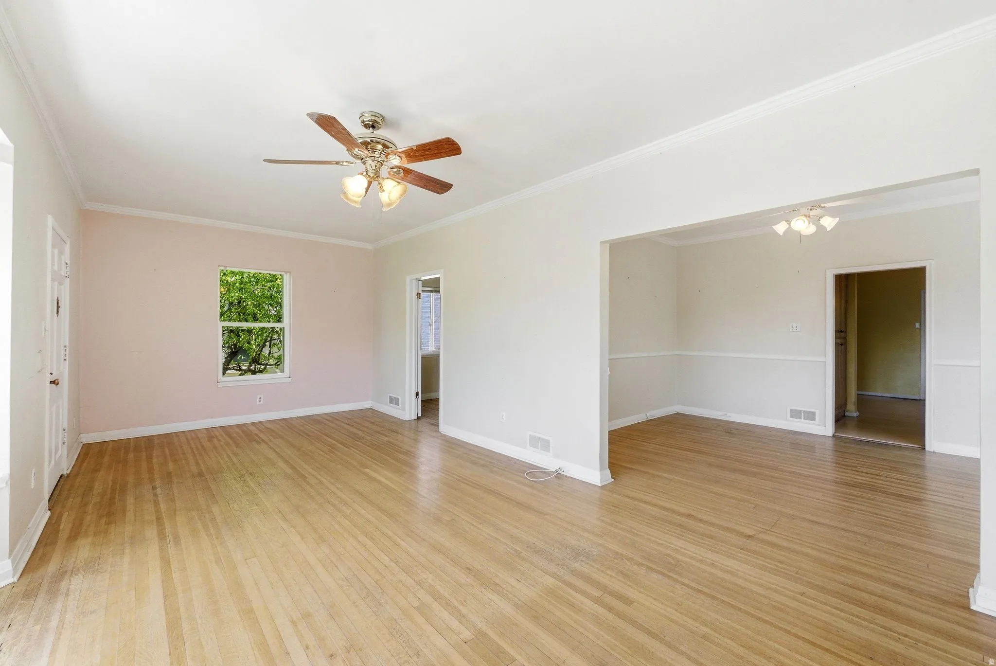 Spare room featuring a ceiling fan, light wood-style floors, and crown molding