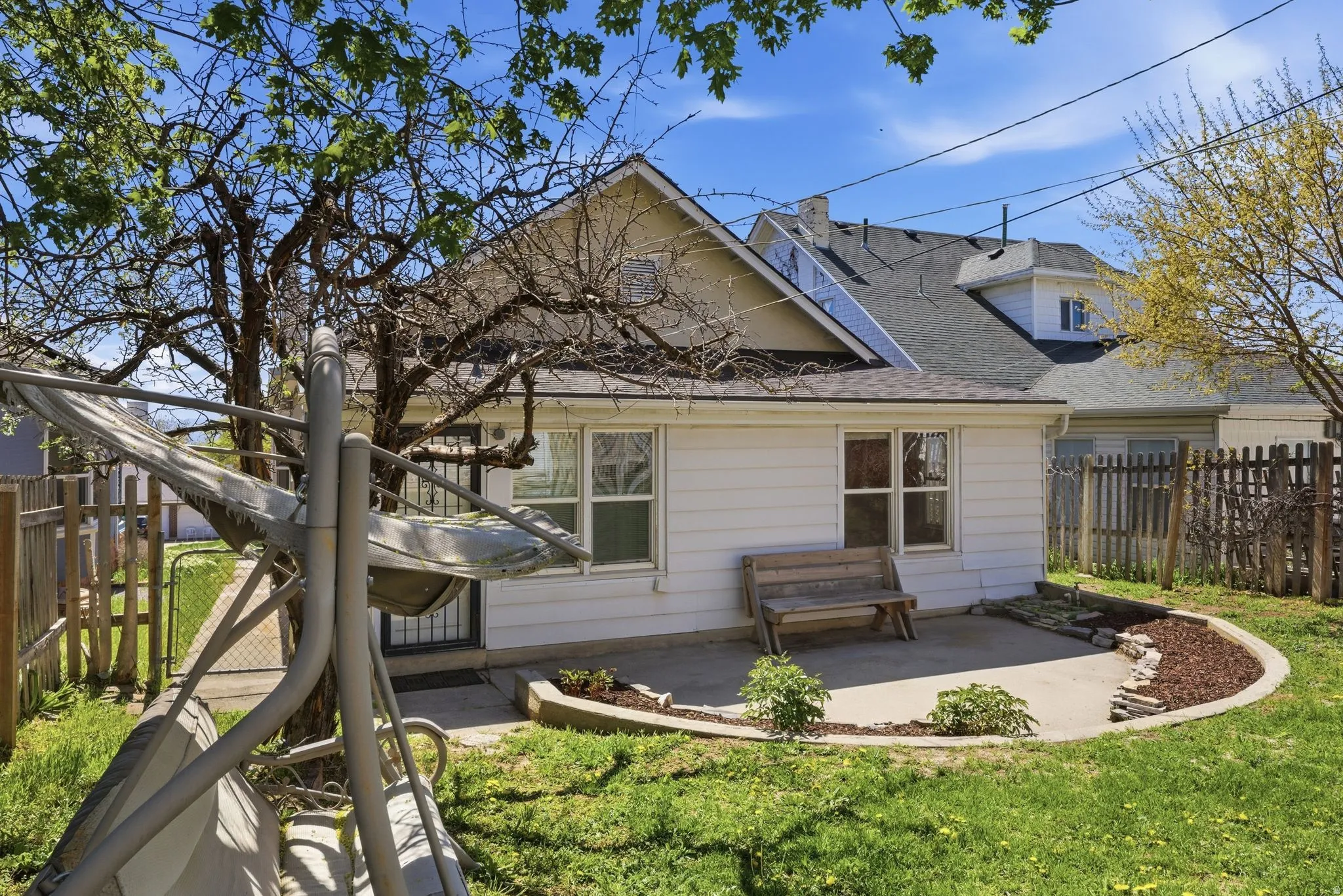 Rear view of house with a fenced backyard, a patio area, and a shingled roof