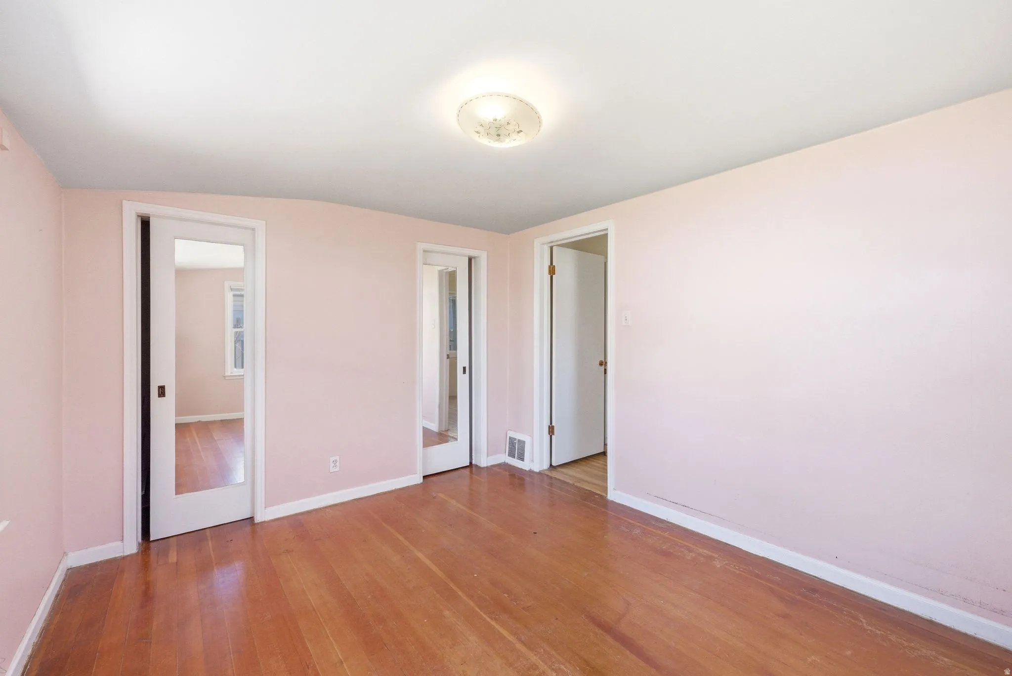Unfurnished bedroom with baseboards and light wood-style flooring