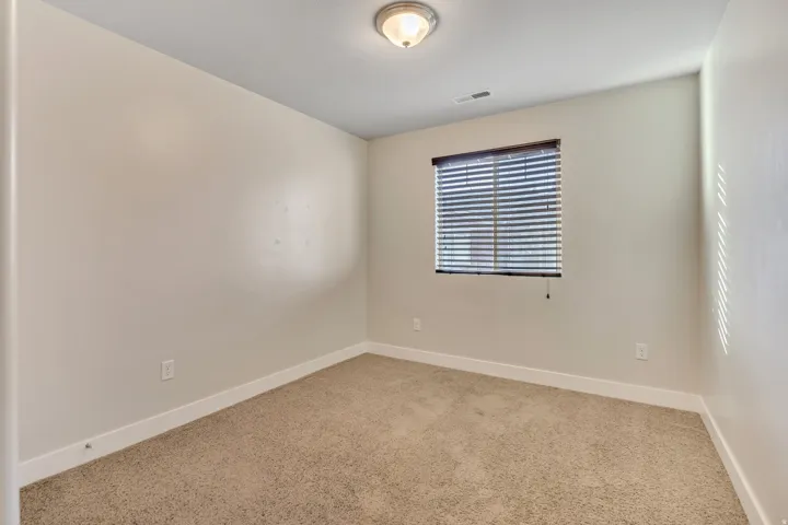 Carpeted spare room featuring baseboards