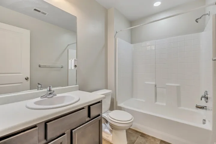 Bathroom with vanity, shower / tub combination, and light tile patterned floors