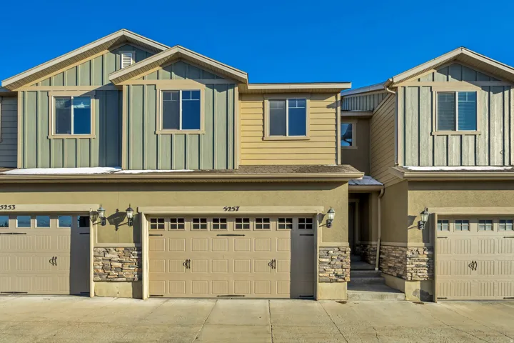 Craftsman inspired home with stone siding, an attached garage, and board and batten siding