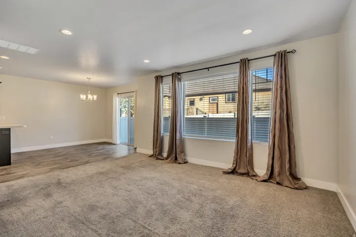 Empty room with dark colored carpet and hanging lights