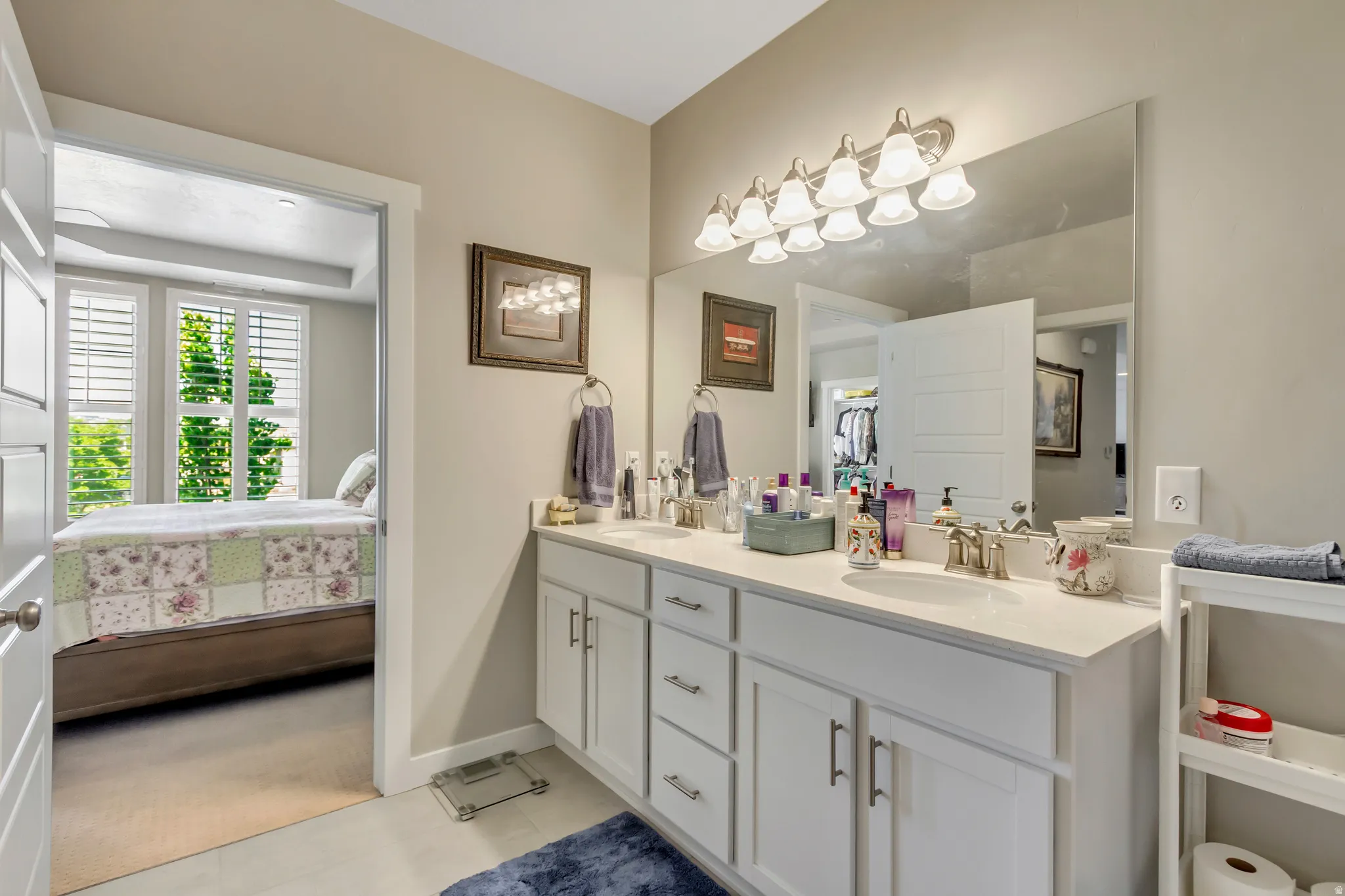 Bathroom with double vanity, connected bathroom, and light colored carpet