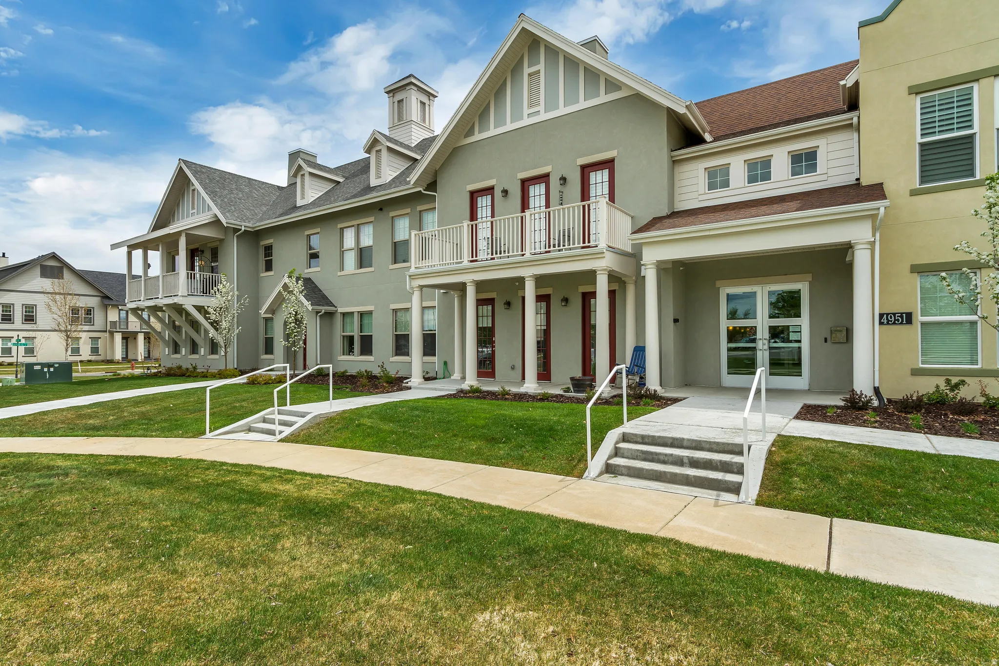 View of front facade with stucco siding, a front yard, a porch, and a residential view