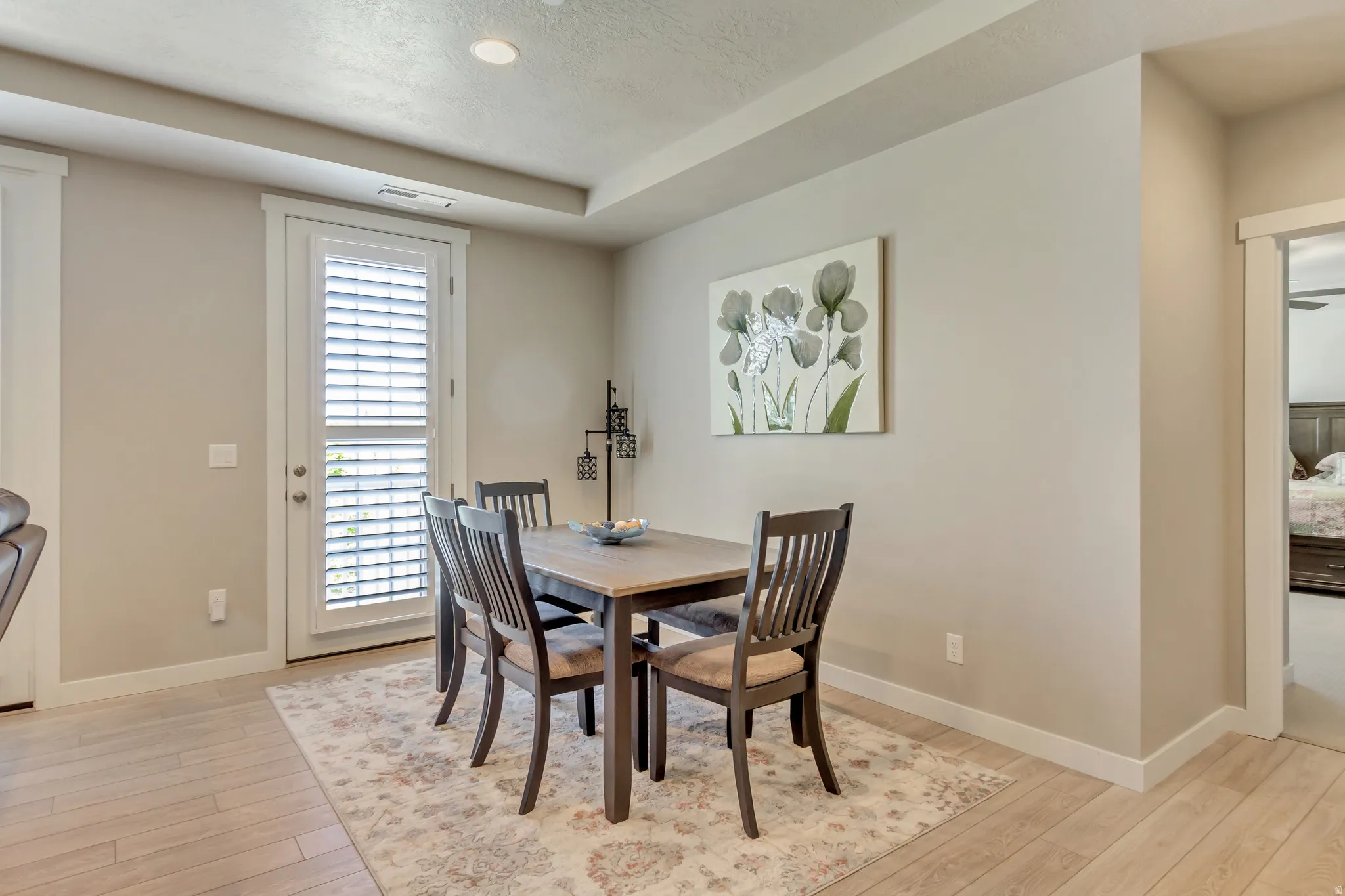 Dining space with light wood-type flooring and a textured ceiling