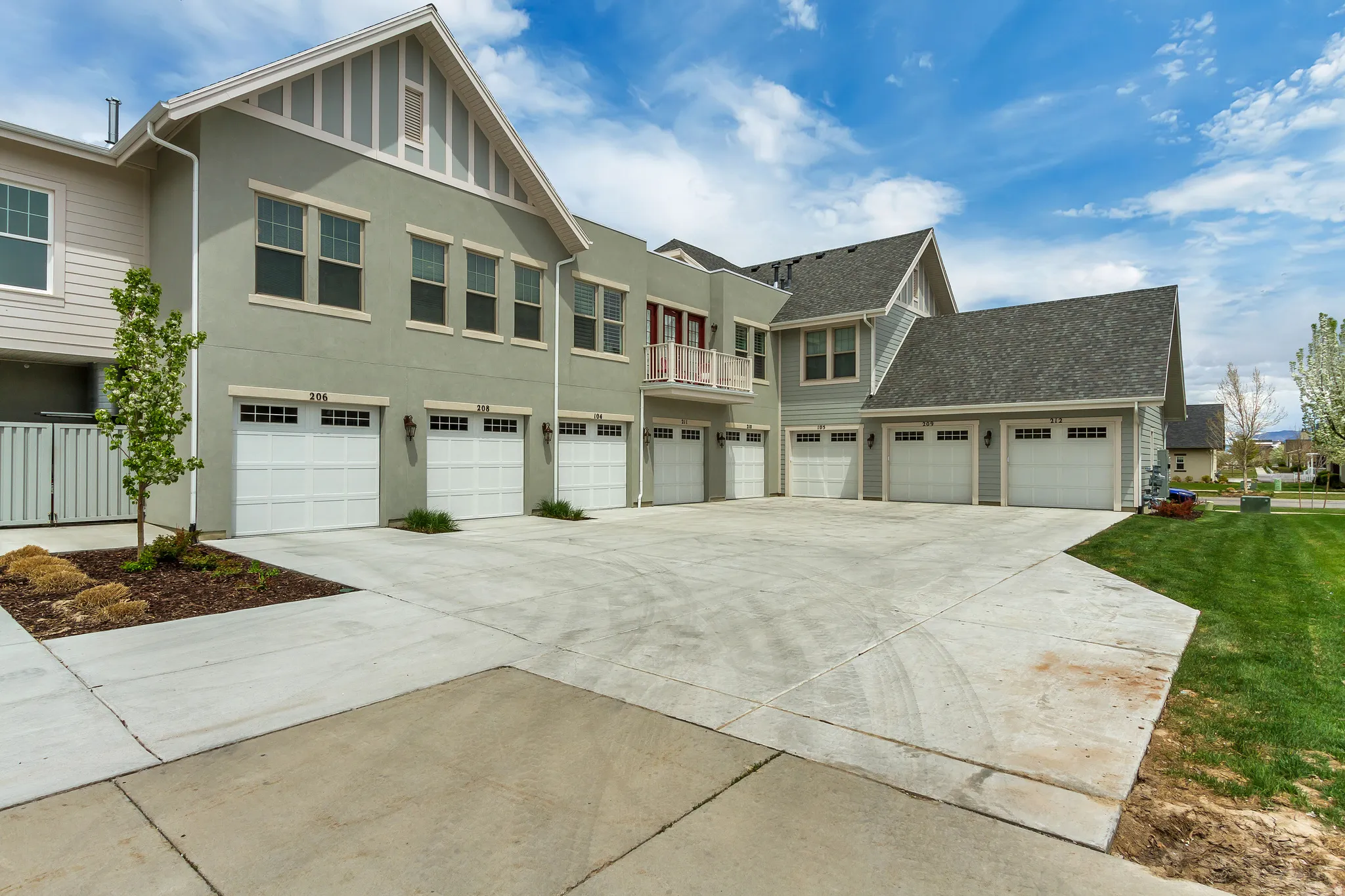 View of front of property featuring driveway, stucco siding, a balcony, and a garage