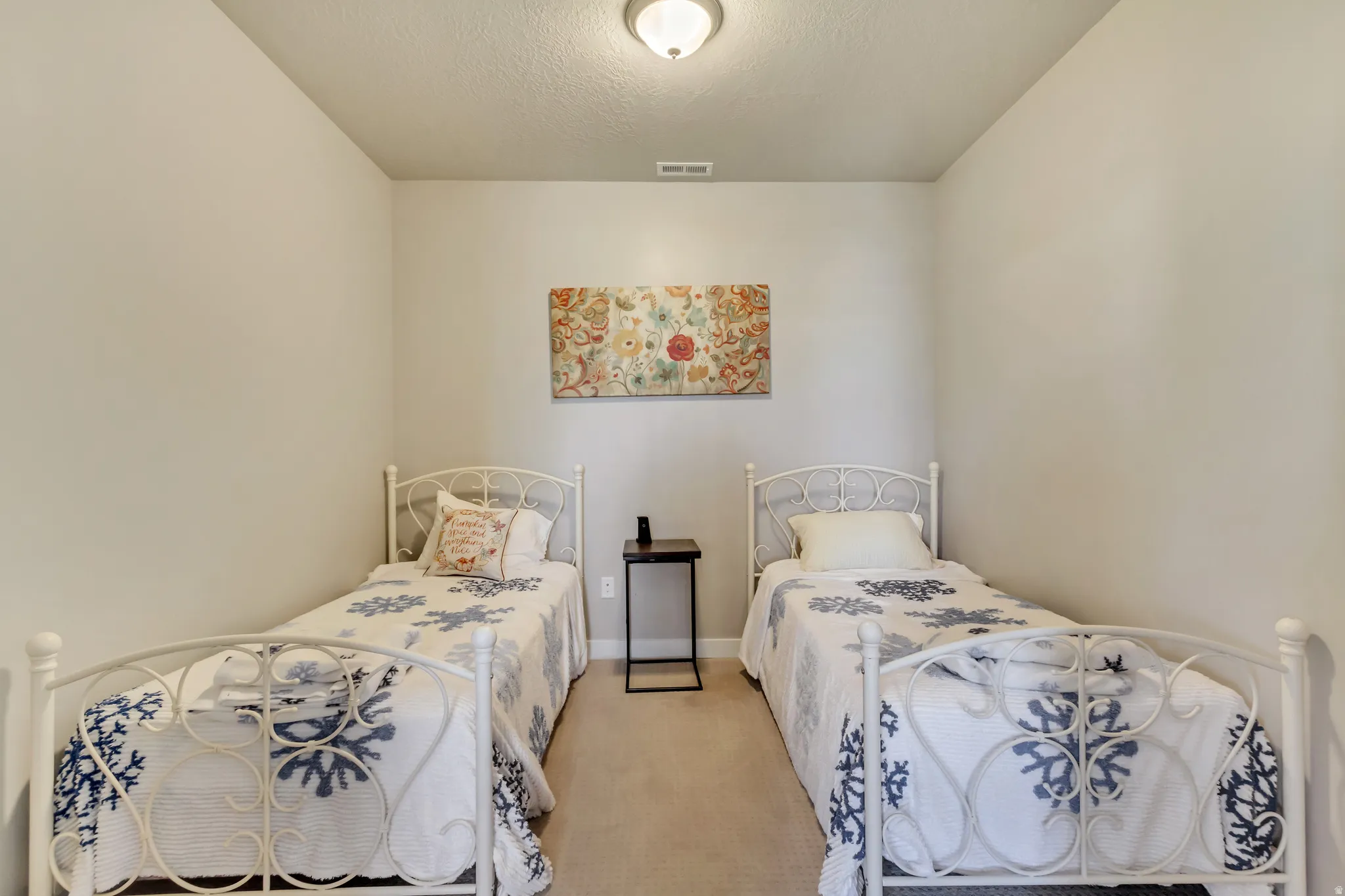 Carpeted bedroom with a textured ceiling and baseboards