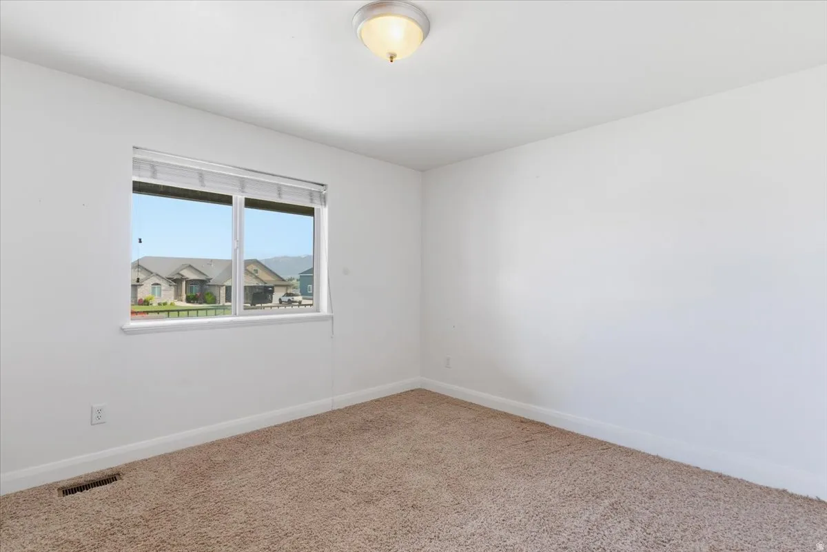 Empty room featuring baseboards and carpet flooring