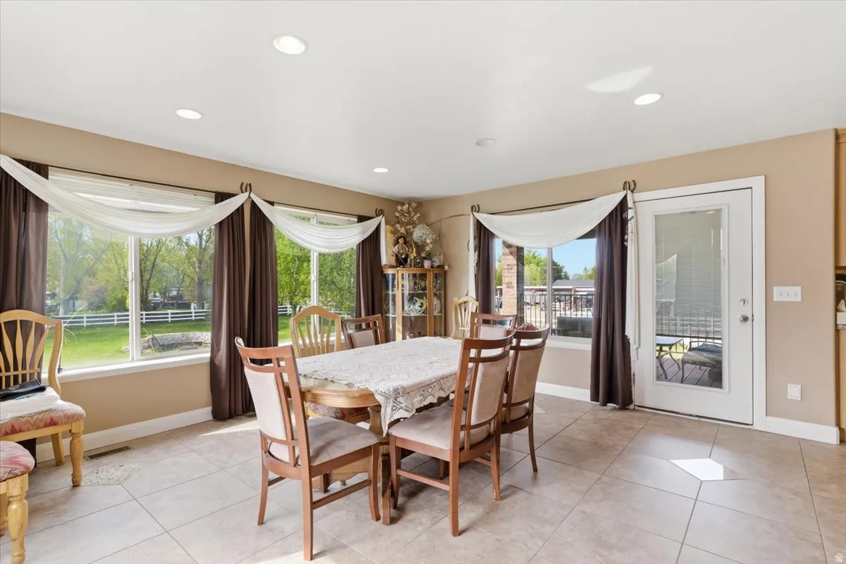 Dining area with light tile patterned floors and recessed lighting