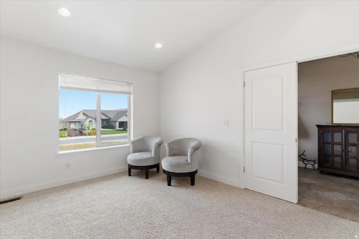 Living area featuring vaulted ceiling, light carpet, and recessed lighting