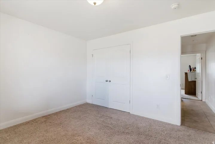 Unfurnished bedroom featuring light colored carpet and a closet