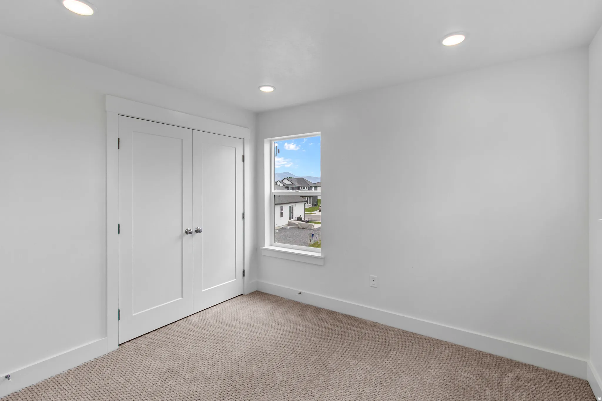 Unfurnished bedroom with light colored carpet, a closet, and recessed lighting