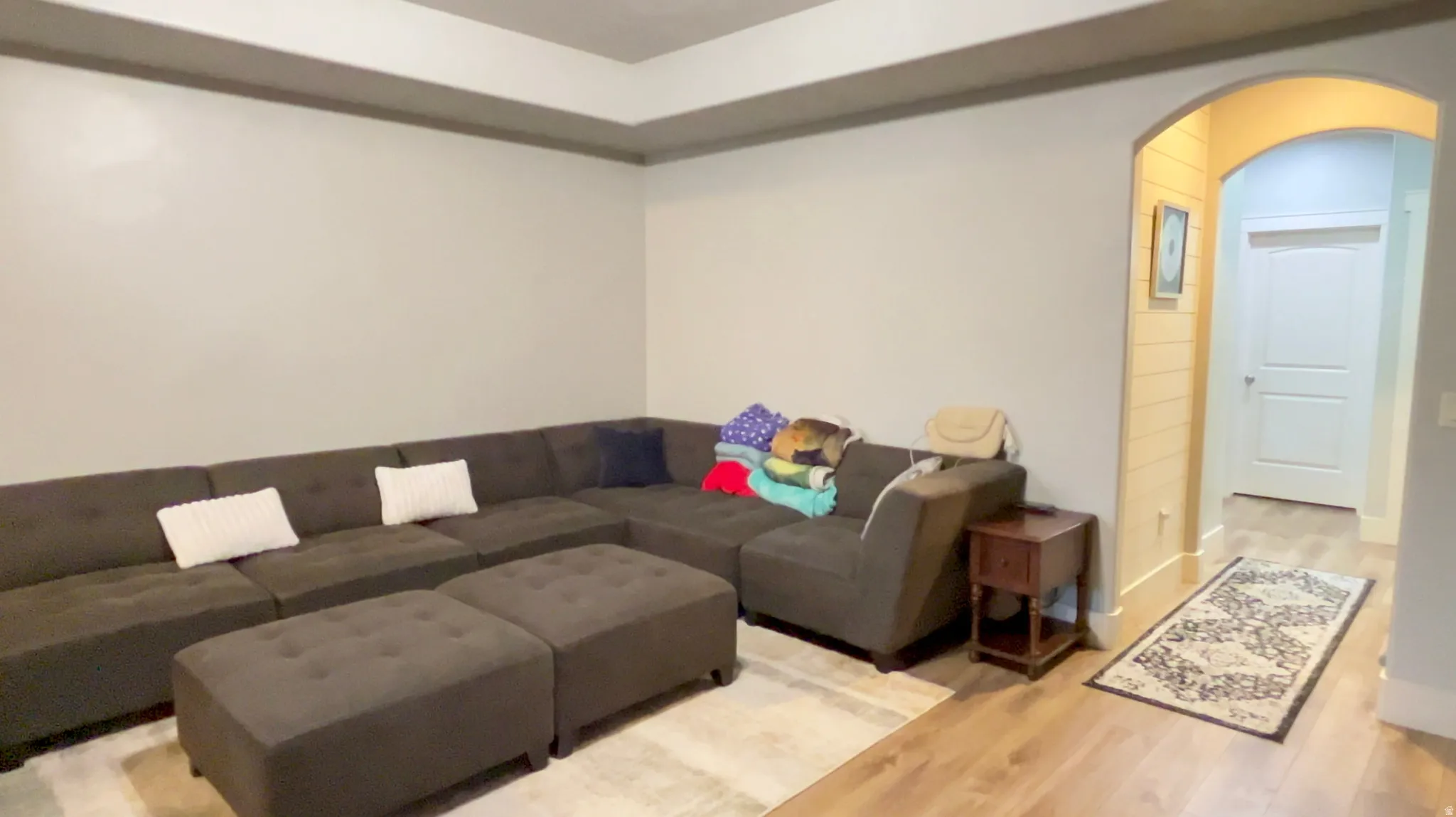 Living room with arched walkways and wood finished floors