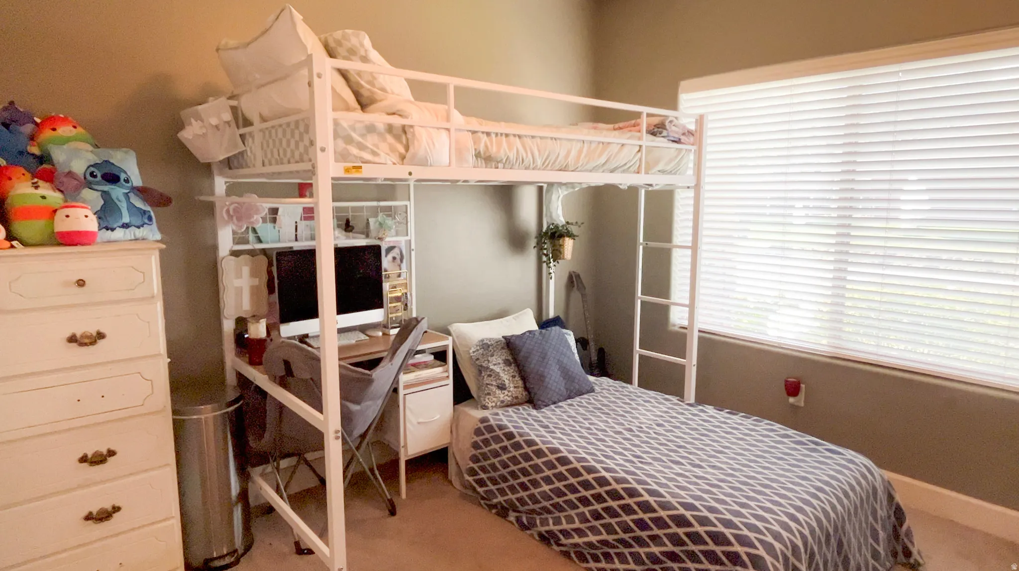 Carpeted bedroom featuring an office area