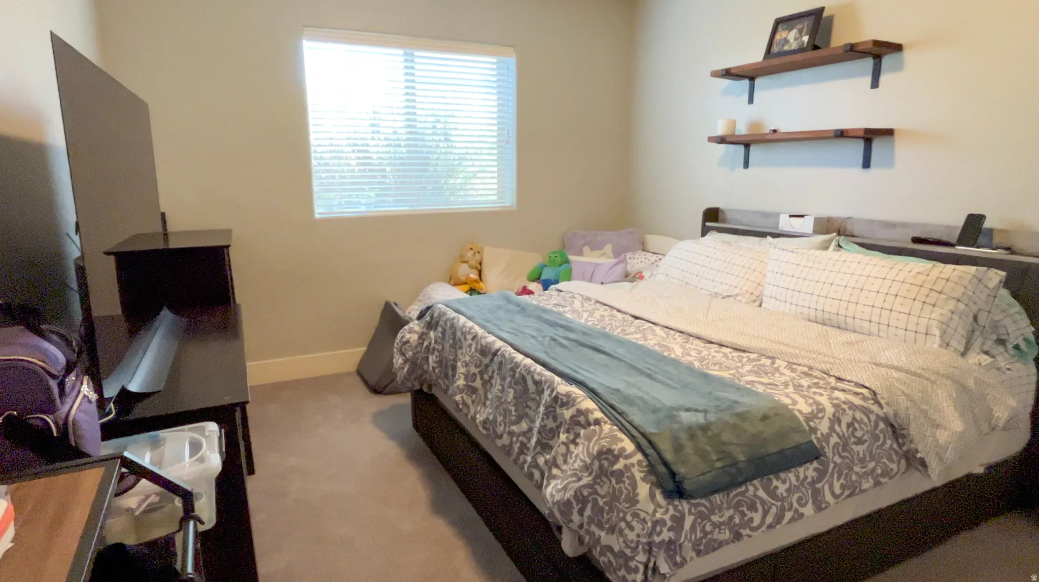 Bedroom with light colored carpet and baseboards