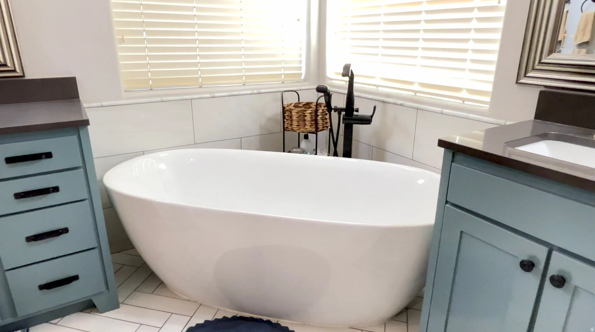 Full bathroom featuring vanity, a soaking tub, and tile walls