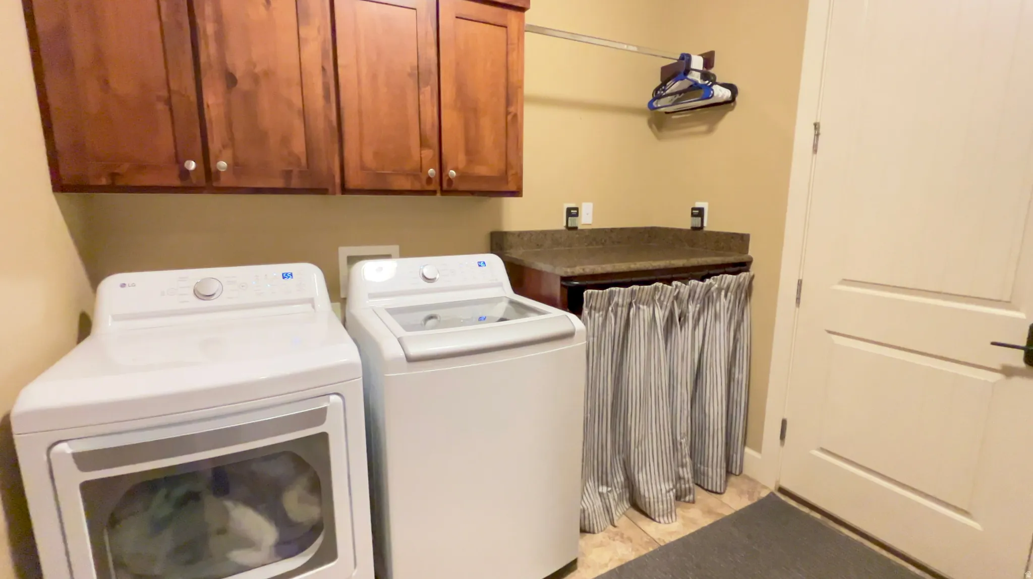 Laundry area with cabinet space and washing machine and clothes dryer