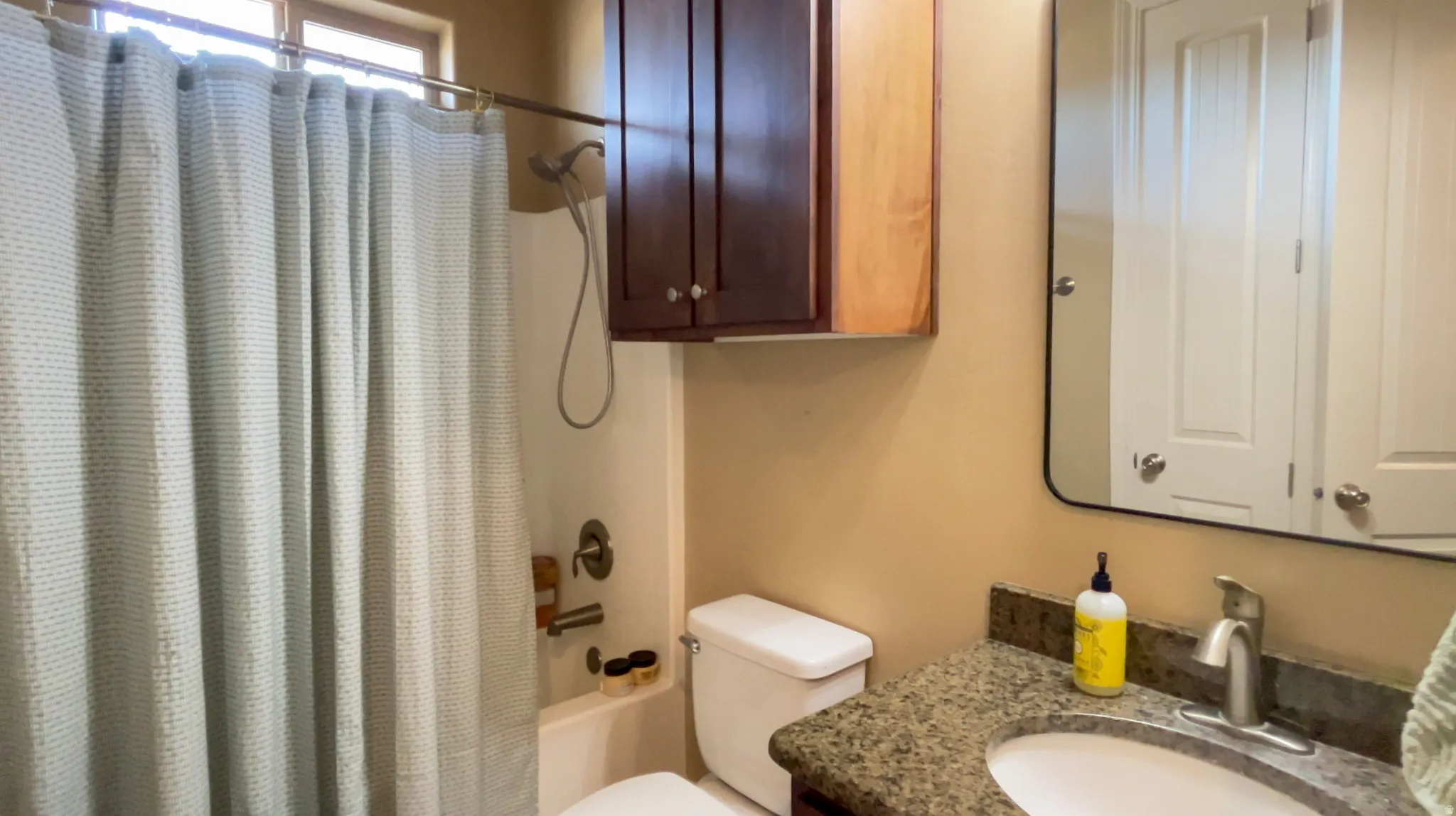Full bathroom featuring vanity and shower / bathtub combination with curtain