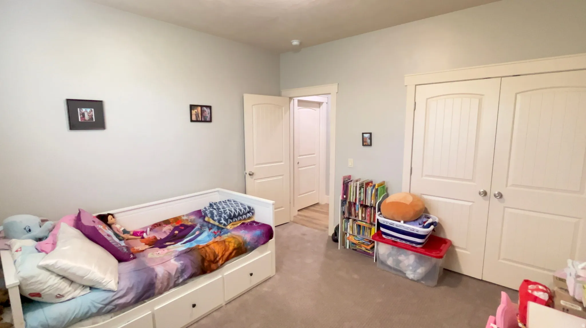 Bedroom with light carpet and a closet