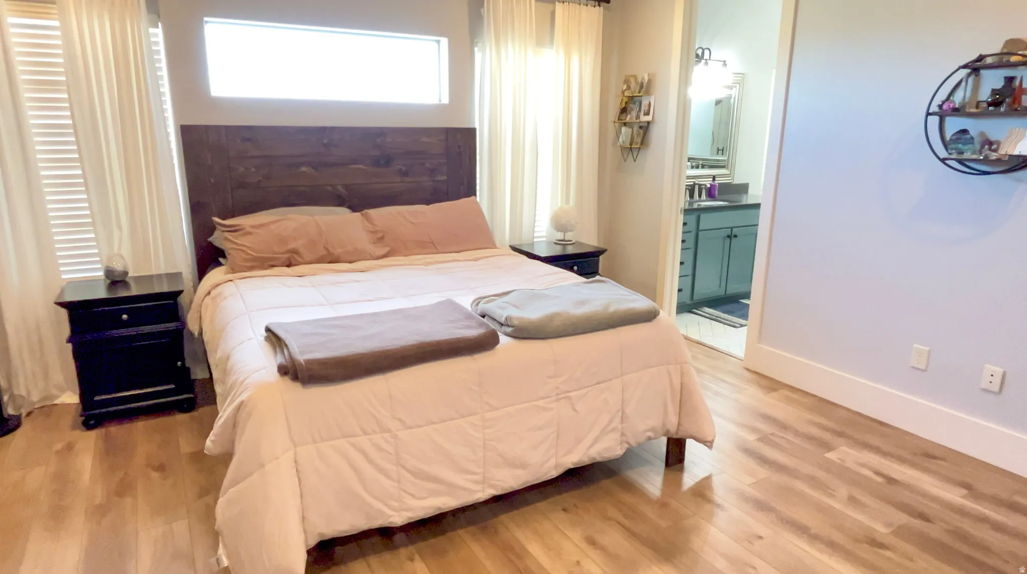 Bedroom with light wood-style floors and ensuite bathroom