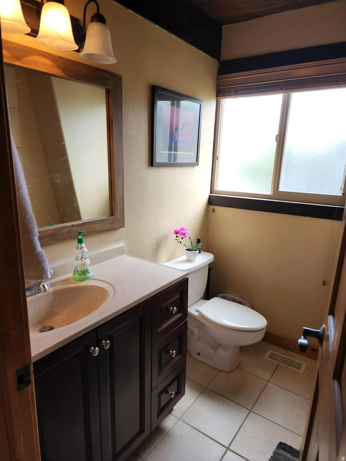 Half bathroom featuring vanity and light tile patterned floors