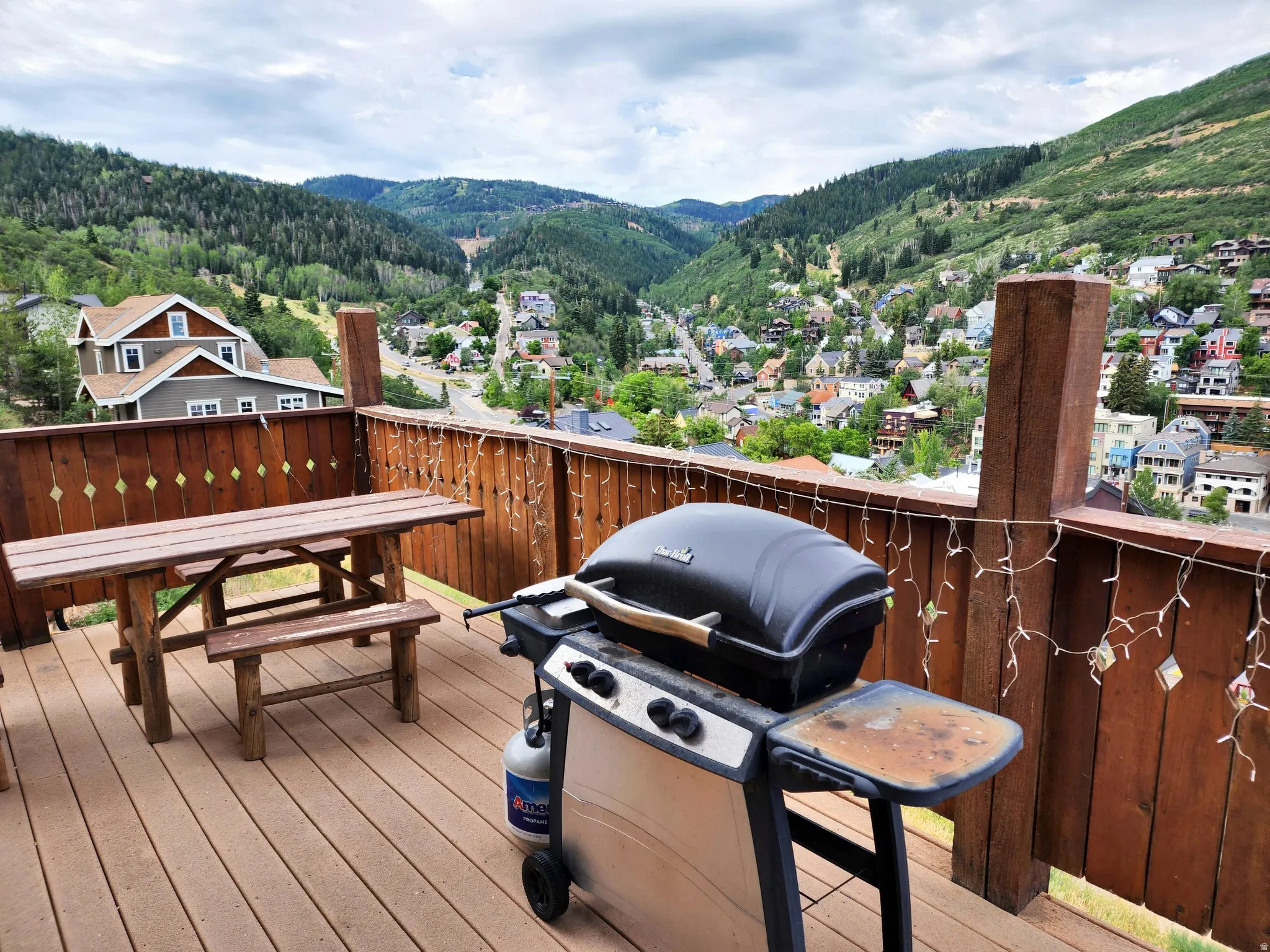 Deck with area for grilling, a mountain view, outdoor dining space, and a residential view