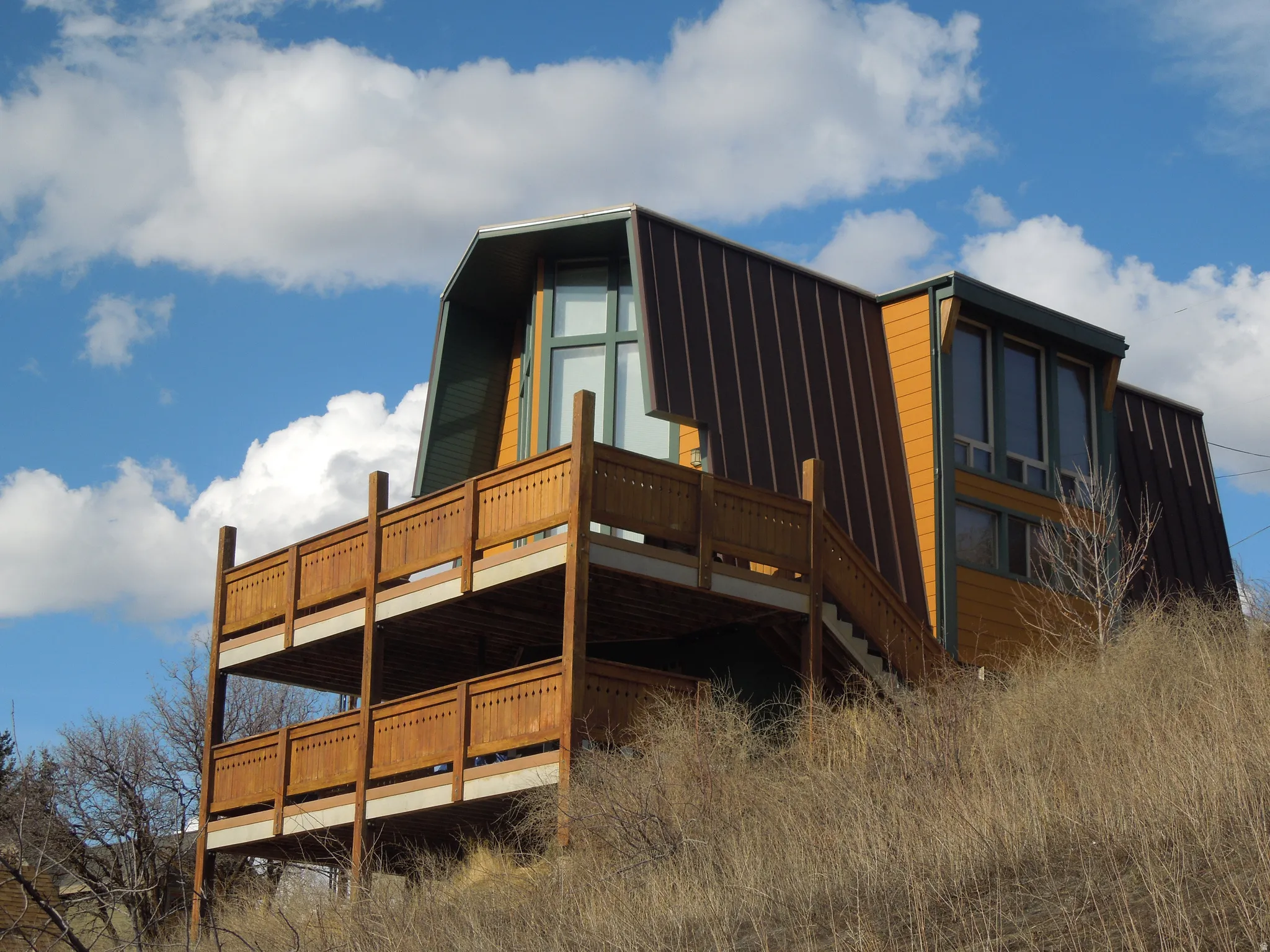 View of side of home featuring a wooden deck