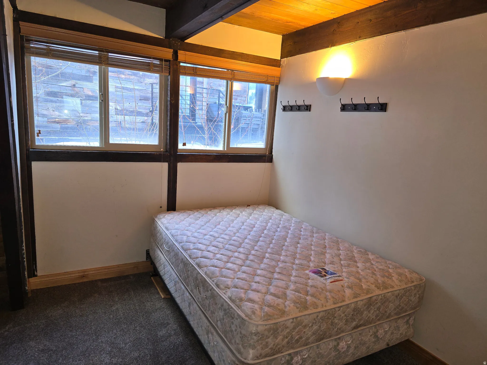 Bedroom featuring dark carpet and beamed ceiling