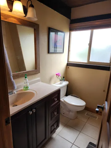 Half bathroom featuring vanity and light tile patterned floors